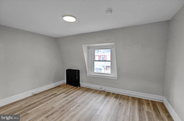 unfurnished room with light wood-type flooring and radiator heating unit