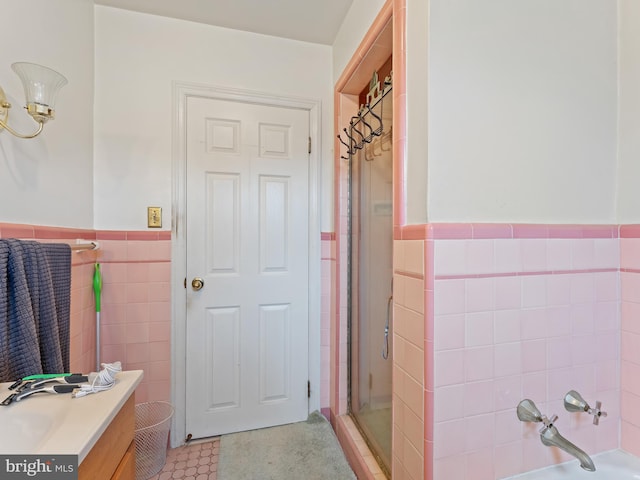 bathroom featuring tile walls, shower with separate bathtub, and vanity