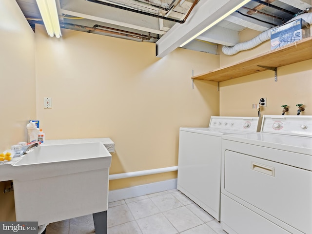 washroom with light tile patterned flooring, sink, and independent washer and dryer