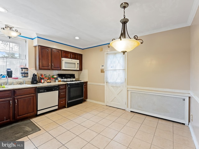 kitchen with sink, ornamental molding, decorative light fixtures, white appliances, and radiator heating unit