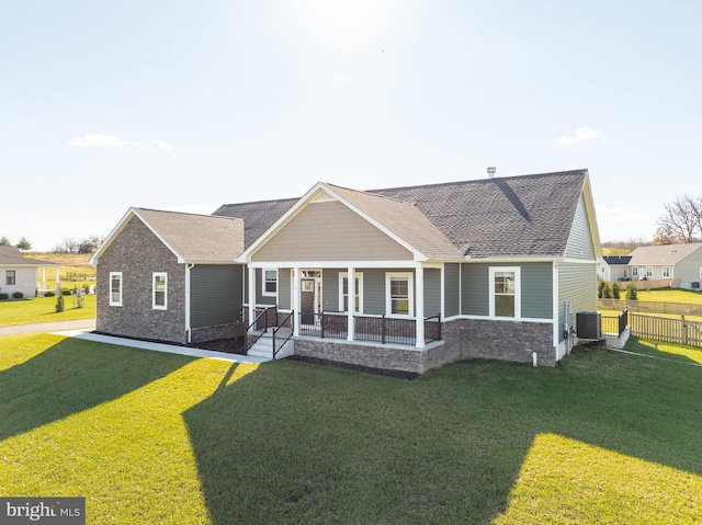 view of front of property with a porch, a front lawn, and central air condition unit