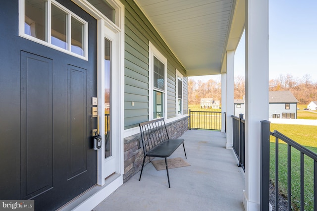 property entrance featuring a porch and a yard