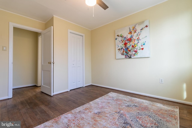 unfurnished bedroom with dark hardwood / wood-style floors, ceiling fan, ornamental molding, and a closet