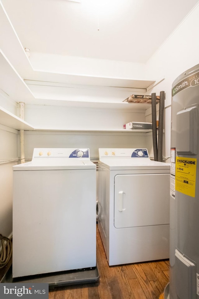 laundry room with dark hardwood / wood-style flooring, electric water heater, and washing machine and dryer