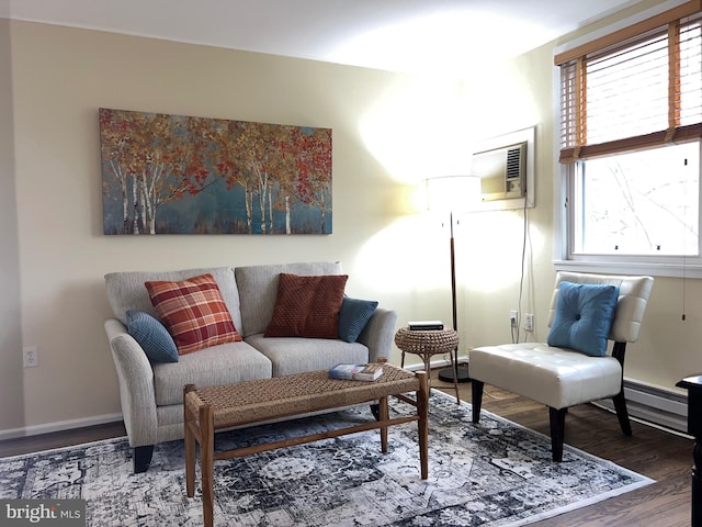 living area with baseboard heating, a wealth of natural light, a wall mounted air conditioner, and hardwood / wood-style flooring