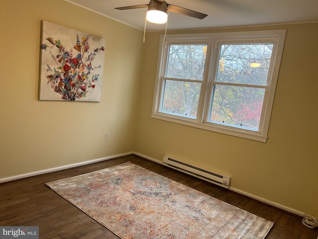 unfurnished room featuring ceiling fan, ornamental molding, dark wood-type flooring, and a baseboard heating unit