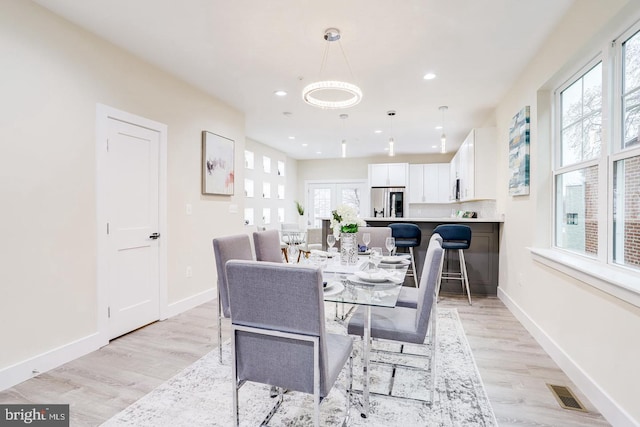 dining room with light wood-type flooring and a wealth of natural light