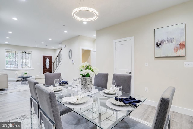 dining area with an inviting chandelier and light hardwood / wood-style floors