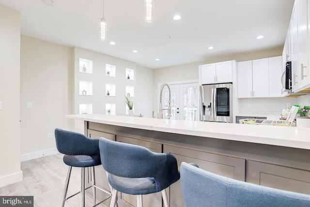 2405 Naylor Rd SE, Washington, DC 20020 - kitchen with stainless steel appliances, light countertops, a breakfast bar area, recessed lighting, and light wood-style flooring