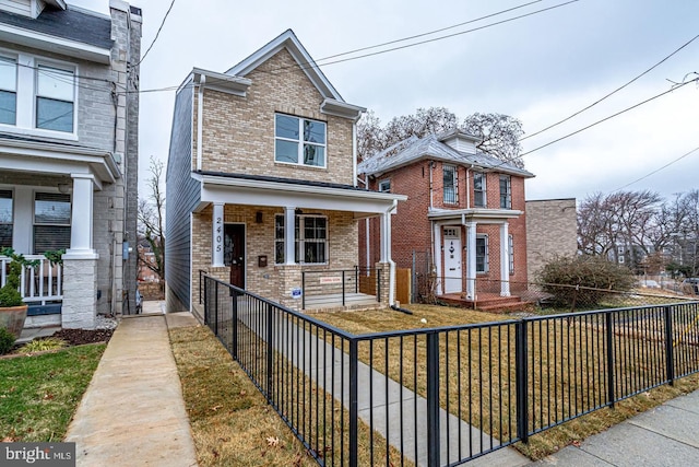 2405 Naylor Rd SE, Washington, DC 20020 - view of front of house with a porch, brick siding, and a fenced front yard