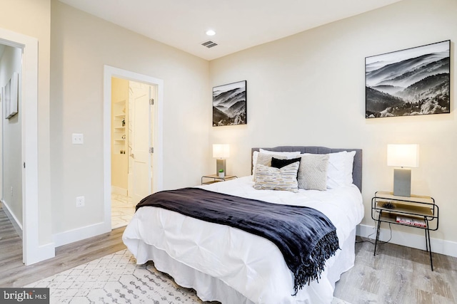 2405 Naylor Rd SE, Washington, DC 20020 - bedroom with wood finished floors, baseboards, ensuite bath, and recessed lighting