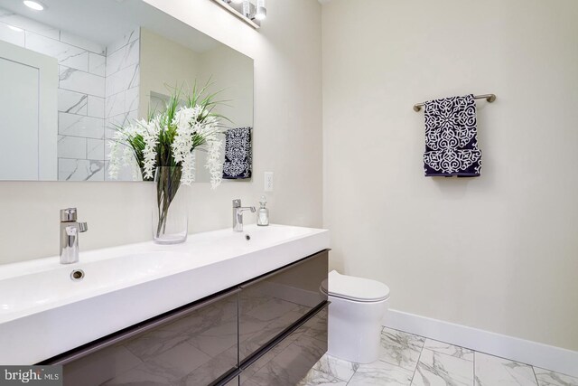 2405 Naylor Rd SE, Washington, DC 20020 - bathroom featuring marble finish flooring, toilet, double vanity, and baseboards