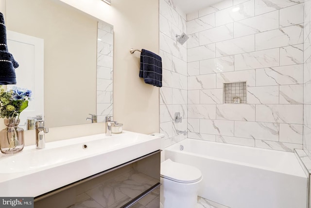 full bathroom featuring vanity, tiled shower / bath, and toilet