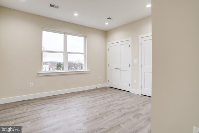 2405 Naylor Rd SE, Washington, DC 20020 - unfurnished bedroom featuring light wood-style floors, recessed lighting, baseboards, and two closets