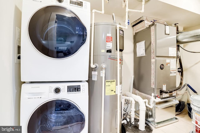 laundry room featuring stacked washing maching and dryer, electric water heater, and light tile patterned flooring