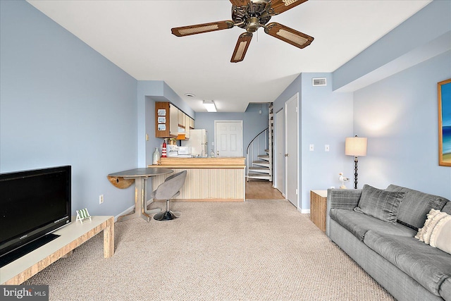 carpeted living room with ceiling fan