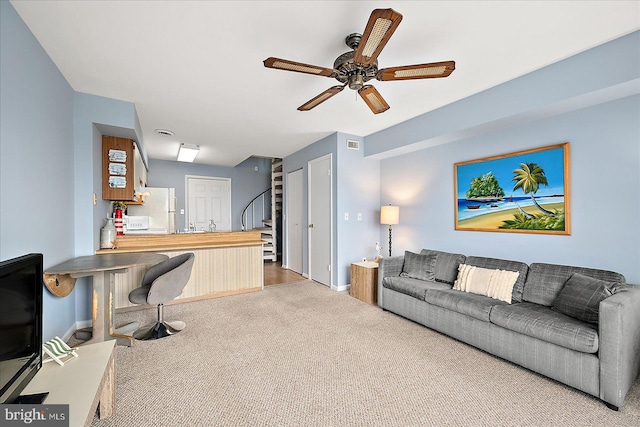 carpeted living room with ceiling fan