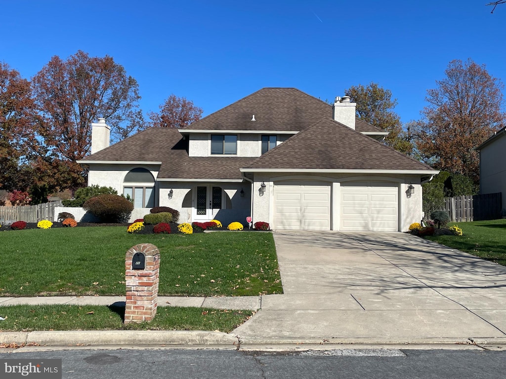 view of property featuring a garage and a front yard