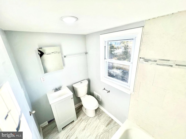 bathroom featuring a tub to relax in, vanity, and toilet