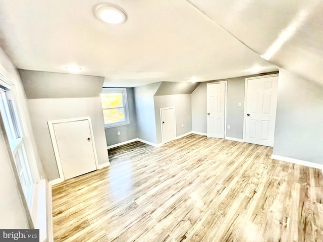 bonus room featuring light wood-type flooring and lofted ceiling