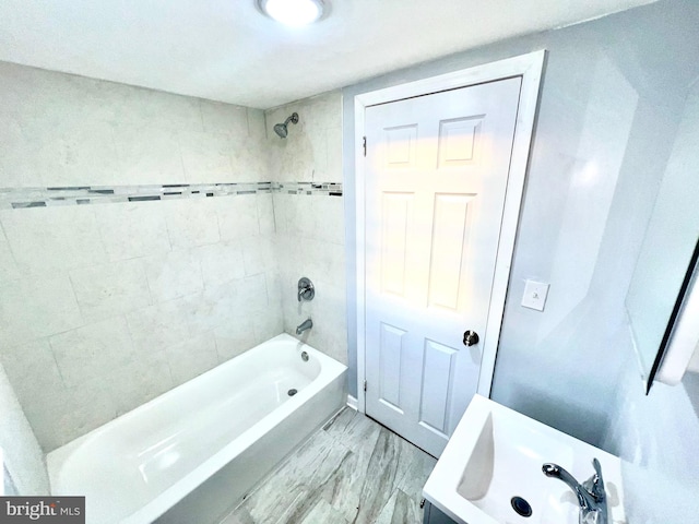 bathroom featuring tiled shower / bath combo and hardwood / wood-style flooring