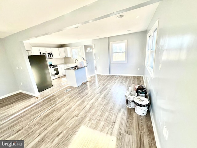 kitchen featuring white cabinetry, sink, light hardwood / wood-style floors, and appliances with stainless steel finishes