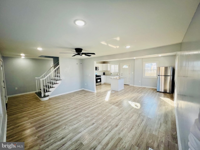 unfurnished living room featuring light hardwood / wood-style floors and ceiling fan