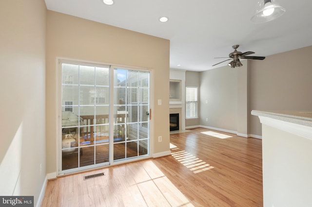 unfurnished living room with ceiling fan and hardwood / wood-style flooring