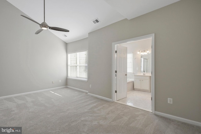 unfurnished bedroom featuring ensuite bathroom, ceiling fan, light carpet, and lofted ceiling