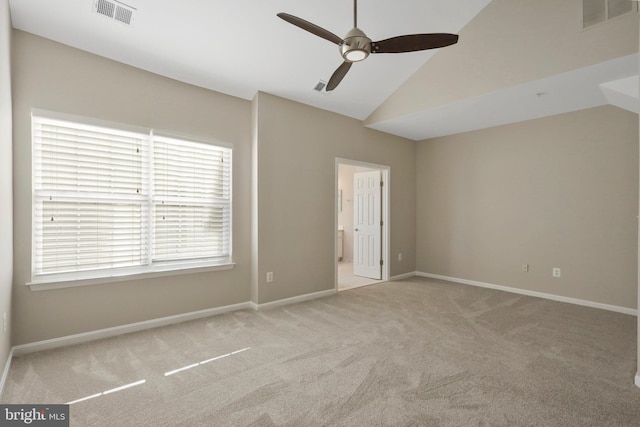 empty room featuring light colored carpet, vaulted ceiling, and ceiling fan