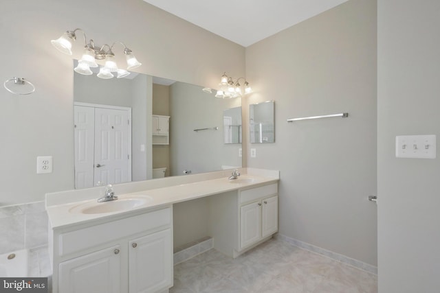 bathroom with tile patterned flooring, vanity, toilet, and an inviting chandelier