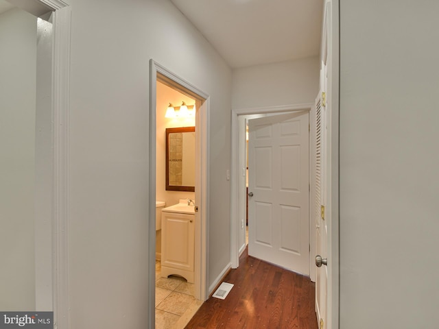 hallway with sink and dark wood-type flooring