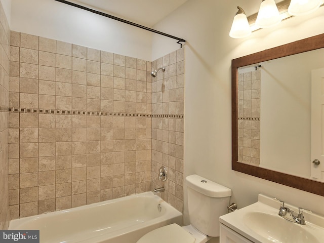 full bathroom featuring toilet, vanity, and tiled shower / bath