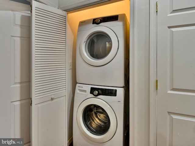 washroom featuring stacked washer and clothes dryer