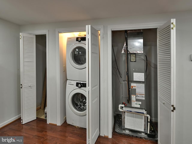 washroom with stacked washer and dryer and dark wood-type flooring