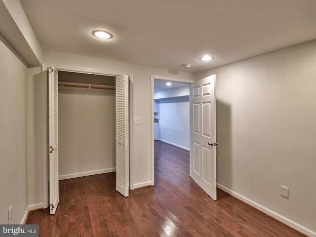 unfurnished bedroom featuring dark hardwood / wood-style floors and a closet