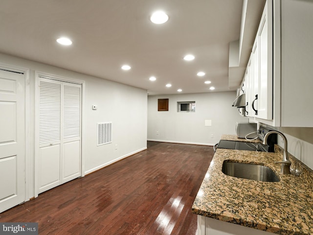 kitchen with sink, white cabinets, and dark wood-type flooring