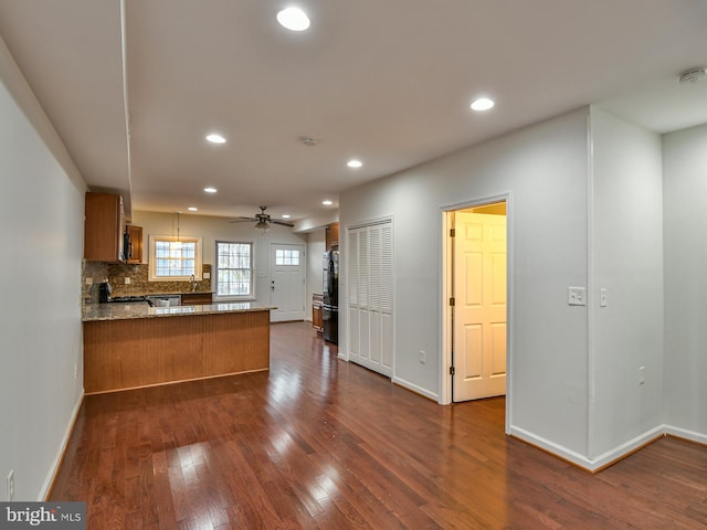 kitchen with ceiling fan, dark wood-type flooring, kitchen peninsula, refrigerator, and decorative light fixtures