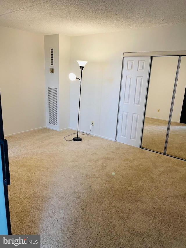 unfurnished bedroom featuring carpet flooring and a textured ceiling