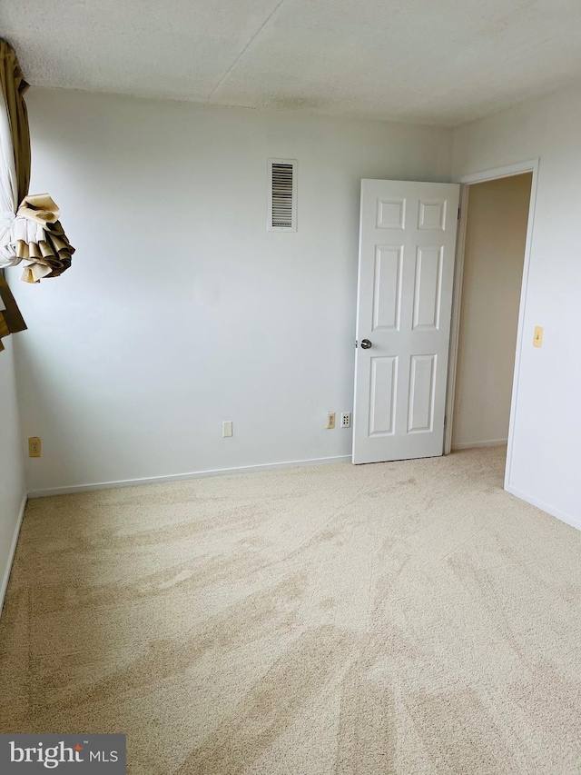 empty room with carpet and a textured ceiling