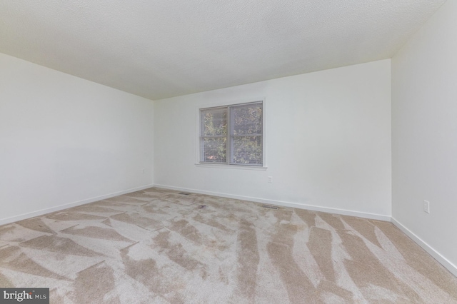 carpeted spare room featuring a textured ceiling