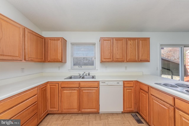 kitchen featuring cooktop, a textured ceiling, white dishwasher, sink, and light parquet flooring