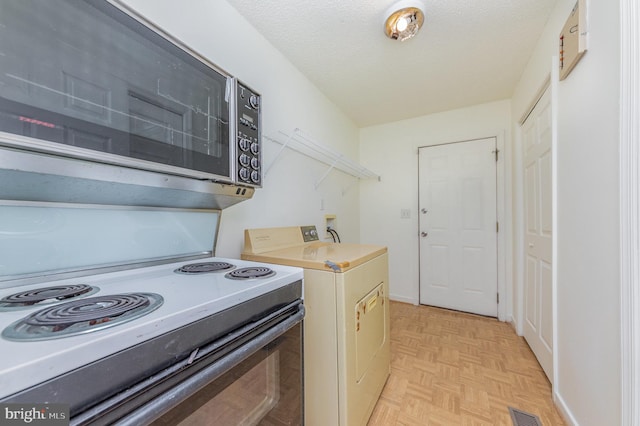 kitchen with white range with electric cooktop, washer / clothes dryer, light parquet floors, and a textured ceiling