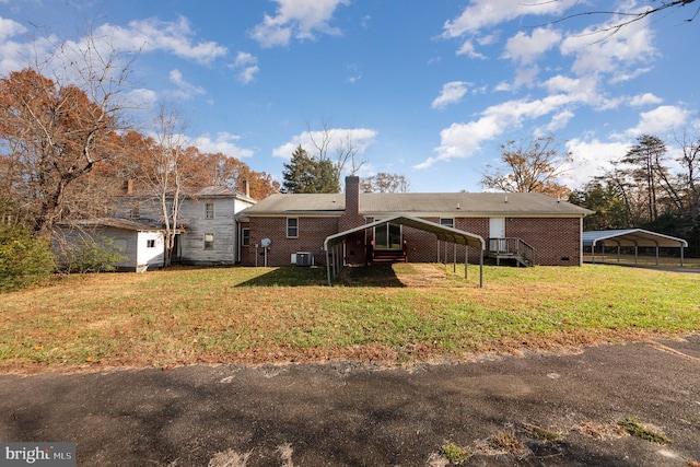 back of property with a yard and a carport