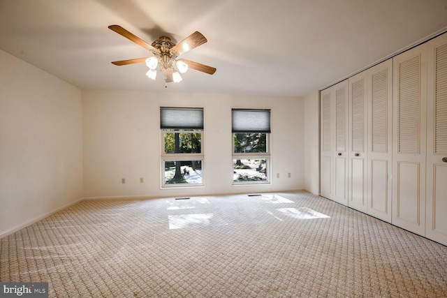 unfurnished bedroom with light carpet, ceiling fan, and a closet