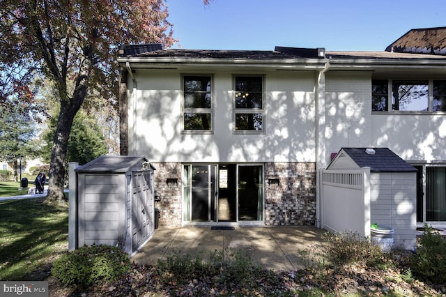 rear view of house featuring a patio and a storage shed