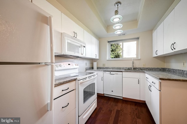 kitchen with sink, white appliances, a raised ceiling, white cabinets, and pendant lighting