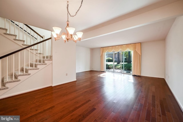 unfurnished living room featuring dark hardwood / wood-style floors and a chandelier