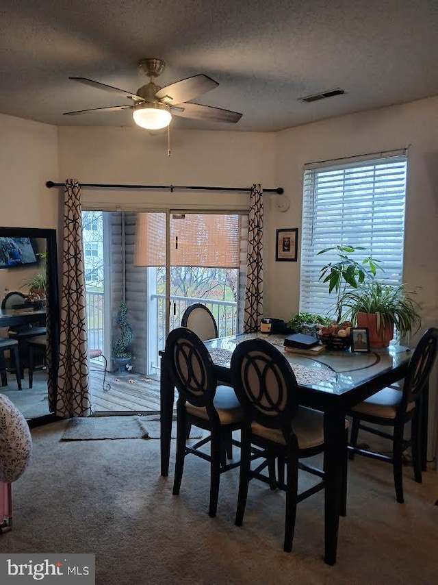 dining space featuring ceiling fan, carpet floors, and a textured ceiling