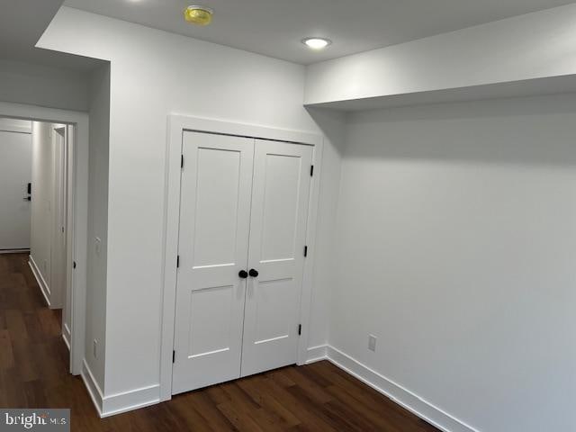 corridor with dark hardwood / wood-style flooring